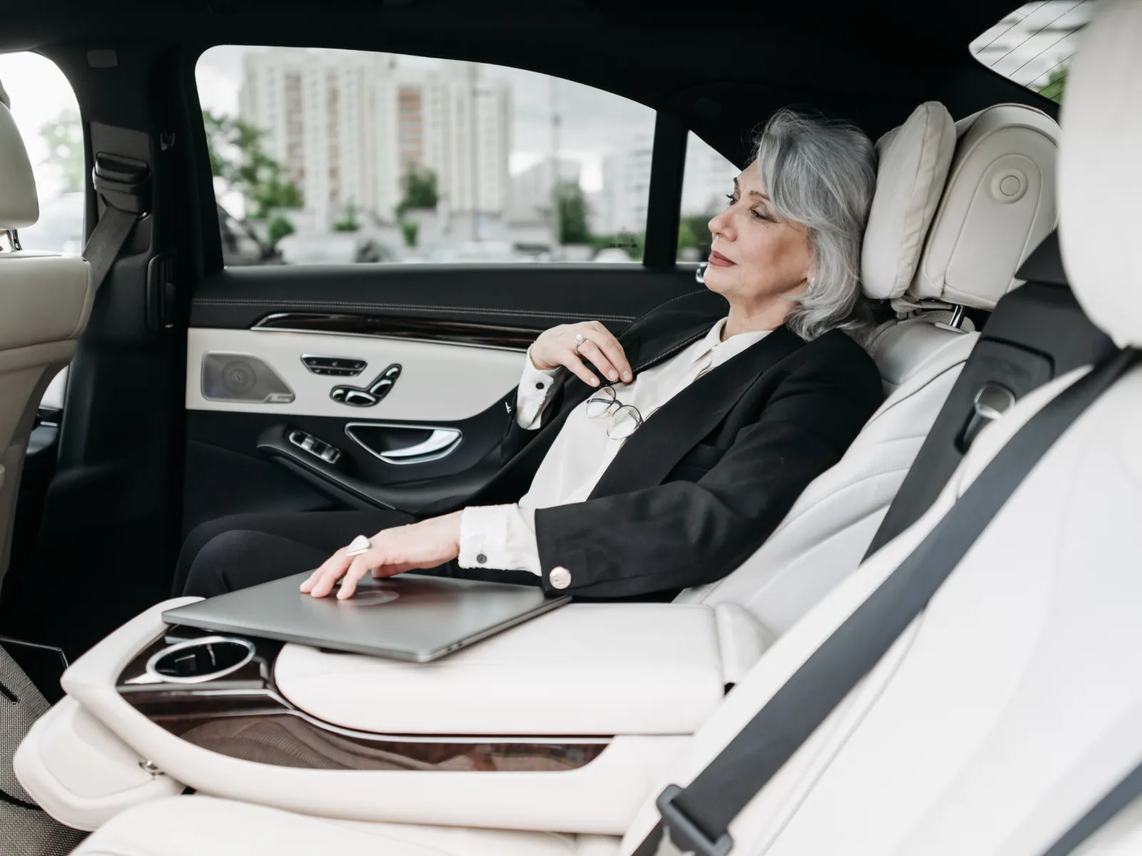 Kobieta w czarnym garniturze na tylnym siedzeniu samochodu